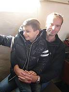 Schülerinnen, Schüler und ein Mitarbeiter zufrieden wirkend im Gottesdienst, beim Ausprobieren der Orgel und nach dem Gottesdienst vor der Kirche, die Schlümpfe zeigend.